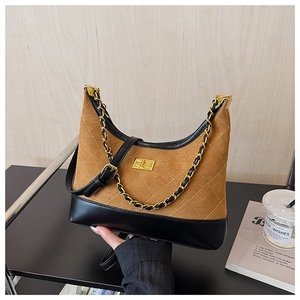 Detail of brown suede crossbody bag with quilted stitching and gold chain strap