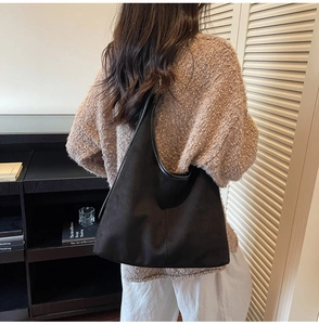 Close-up of black faux suede tote bag featuring a matte finish and soft vintage texture