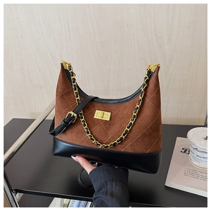 Detail of quilted brown suede bag with black leather base and gold chain strap