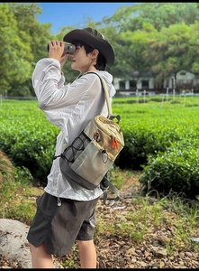 Vue de style de vie extérieur du sac à dos de randonnée kaki et gris dans un jardin