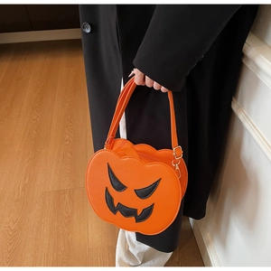 Detail of orange pumpkin shaped handbag with black face embroidery and PU leather texture