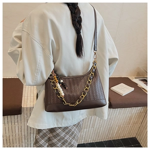 Detail of dark brown woven suede hobo bag with gold chain and colorful bead tassels