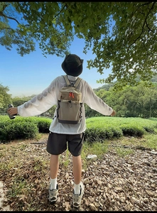 Sac à dos de loisirs en patchwork kaki présenté dans un paysage de jardin de thé vert