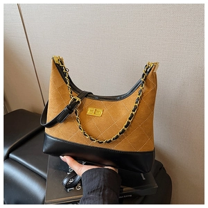 Detail of quilted leather messenger bag with gold clasp and chain strap