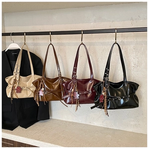 Détail de quatre sacs à bandoulière plissés vintage en couleurs variées avec breloques