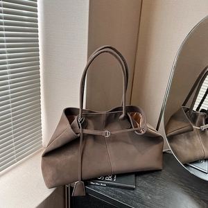 Close-up of deep brown matte tote bag featuring silver buckle detail and soft leather texture