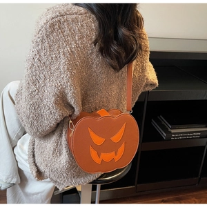 Detail view of the Halloween pumpkin crossbody bag with orange face and adjustable strap