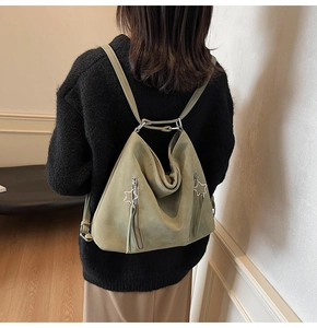 Detail of sage green suede tote bag featuring star zippers and large capacity design