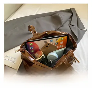 Intérieur spacieux du cabas en cuir marron brillant avec tablette et objets essentiels