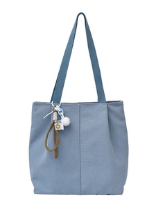 Large light blue canvas tote bag with vertical stripes and fuzzy ball charms