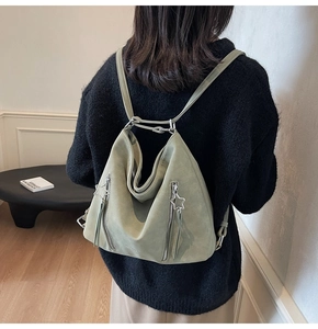 Detail of light green hobo backpack featuring star zipper pull and suede texture