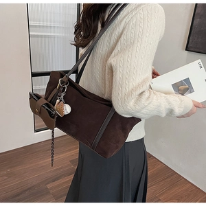 Detail of suede shoulder bag with baseball glove pendant and matching leather pouch