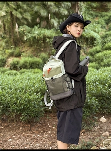 Détail d'un sac à dos de randonnée vert olive avec filet et cordons dans la forêt