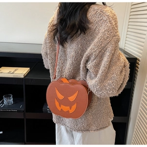 Detail of a model wearing a pumpkin-shaped crossbody bag with Halloween smile patterns
