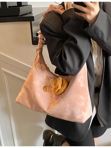 Pink pleated hobo bag with marble pattern, shoulder strap, and bear plush keychain