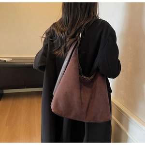 Detailed view of the large suede tote bag texture and long shoulder strap on model