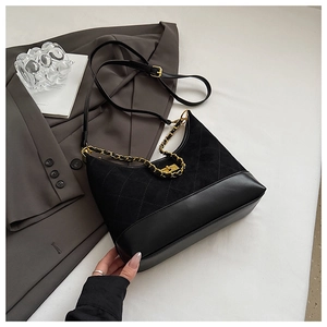 Detail showing matte quilted suede texture and gold chain on black crossbody bag