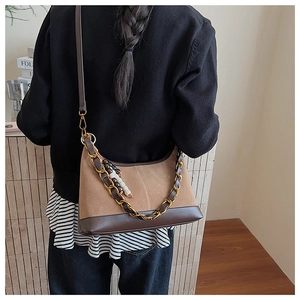 Detail of vintage faux suede hobo bag with bronze chain and wooden bead accessories