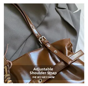 Détail d'un sac cabas marron en similicuir avec bandoulière réglable et foulard à carreaux