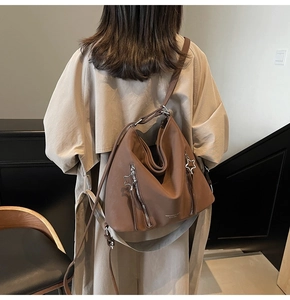 Detail of a brown hobo bag showing the star-shaped zipper and soft pleated texture