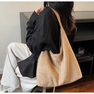 Detailed close-up showing the soft matte texture of the camel suede shoulder tote bag