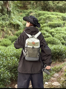 Détail du sac à dos de randonnée avec cordons orange et poche filet sur modèle