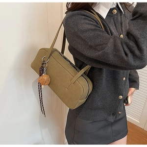 Detail der matten olivgrünen Tasche aus Wildlederimitat mit Pilzanhänger am Griff