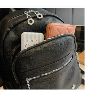 Detail of the front zipper pocket on black pebble leather backpack showing large capacity