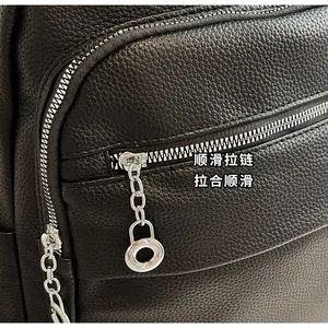 Detail of smooth silver zipper with stylish metal ring puller on black pebble leather bag