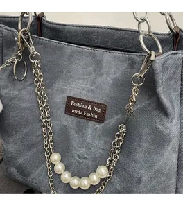 Detail der blauen Denim-Tasche mit Silberkette und großen weißen Perlen-Elementen