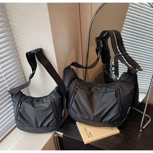 Close-up of black Oxford crossbody bags in two sizes with multiple zipper pockets