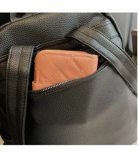 Close-up of a hidden back zipper pocket on a black lychee texture leather backpack
