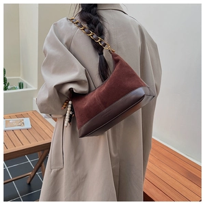 Detail of vintage brown suede hobo bag with gold chain strap and wooden bead accents