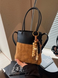 Chic quilted suede bucket bag in brown and black with wooden bead tassel and strap