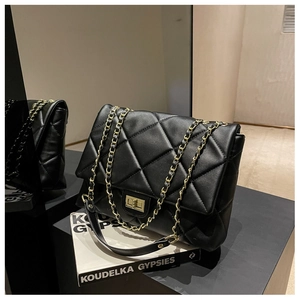 Detailed view of black quilted pattern texture with gold chain strap on a flap bag