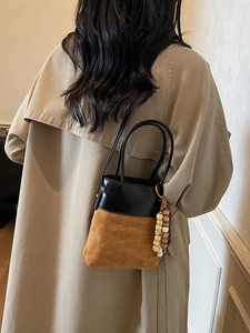 Minimalist patchwork bucket bag in black leather and brown suede with quilted patterns