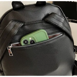 Detailed close-up of the anti-theft back zipper pocket on a black litchi pattern backpack