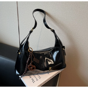 Détail du sac à bandoulière en cuir verni noir brillant avec fermeture éclair dorée