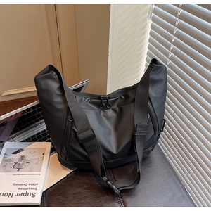 Detailed shot of crescent nylon crossbody bag with dual zippers and woven brand label
