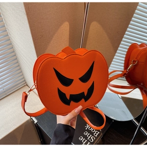 Detail of orange pumpkin crossbody bag with black jack-o'-lantern face and gold zipper