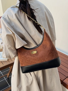 Quilted brown suede dumpling bag with gold chain strap shown on a model back view