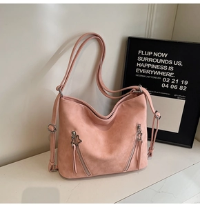Detail of pink dusty rose tote bag with star zippers on white marble surface
