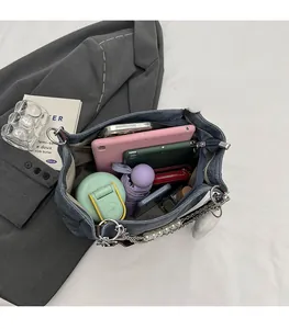 Detail der blauen Denim-Tragetasche mit großem Innenraum für Essentials und Perlenkette