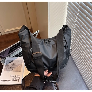 Detail view of black oxford nylon crossbody bag with durable zippers and laptop accessories
