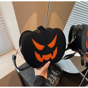 Detail of Halloween pumpkin bag showing side zipper, gold hardware, and orange face design