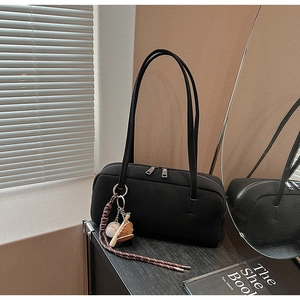 Detail der schwarzen Boston Bag mit silbernen Reißverschlüssen und Baseball-Anhänger