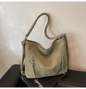 Detailed close-up of sage green tote featuring star zipper pulls and matte leather texture