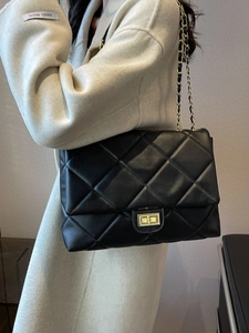 Classic black quilted shoulder bag with gold square lock and chain strap on model