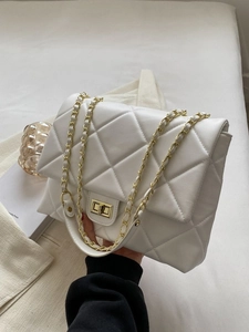 White quilted crossbody bag with gold chain strap and turn-lock closure in premium finish
