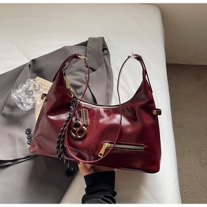Sac hobo bordeaux chic avec finition brillante et détails de pendentif sphérique unique